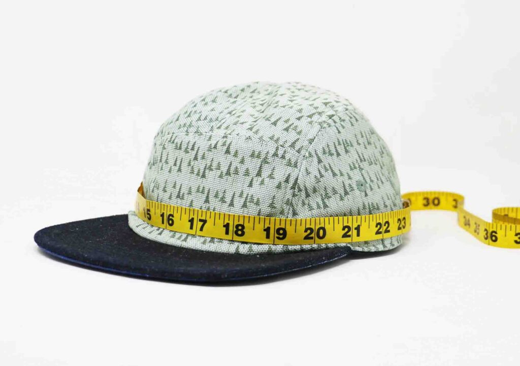 Cinta métrica alrededor de la gorra de béisbol para medir el tamaño de la cabeza