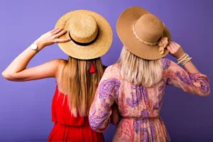 Two women with straw hats facing backward
