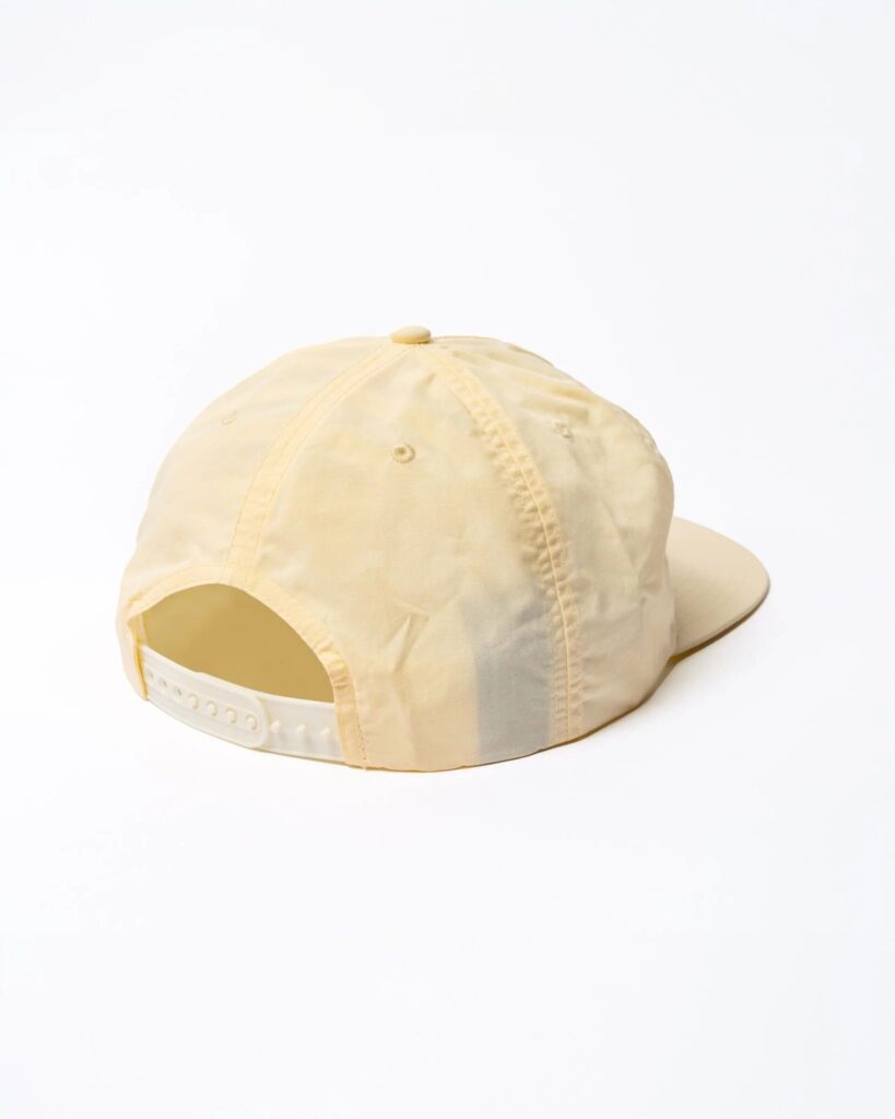 Rear view of light yellow baseball cap with adjustable snap closure