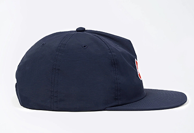 Side view of navy blue baseball cap with flat brim and embroidered logo.