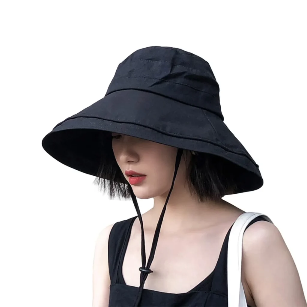 Woman wearing black wide brim sun hat with chin strap.