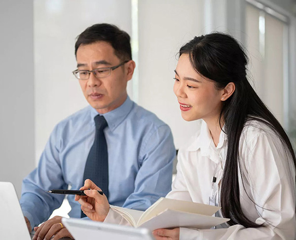 Man and woman discussing documents together in office setting.