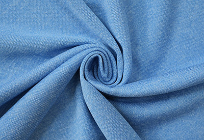 Close-up of blue denim fabric showing textured weave and folds.