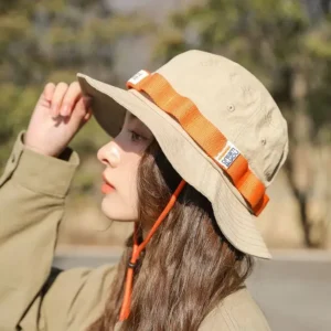 Femme portant un chapeau beige avec une bande orange