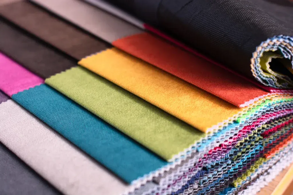 Various colorful fabric swatches rolled and stacked