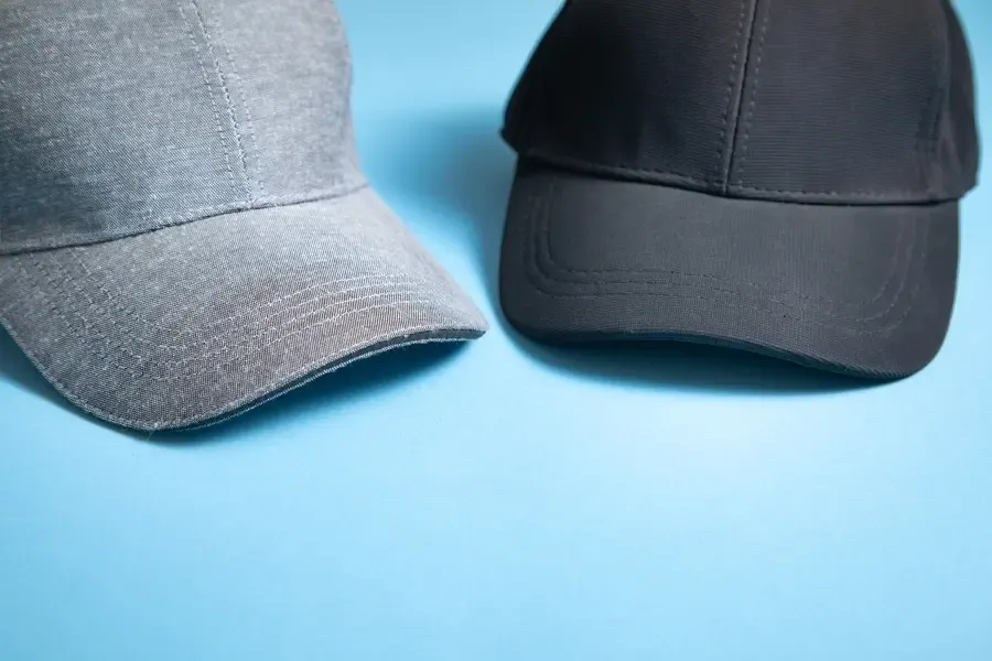 Kappen aus grauer Baumwolle und schwarzem Polyester auf blauem Hintergrund