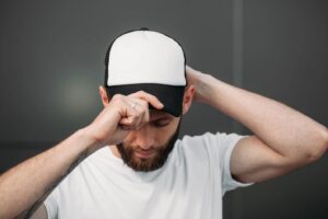 Hombre ajustando la gorra de camionero a la cabeza