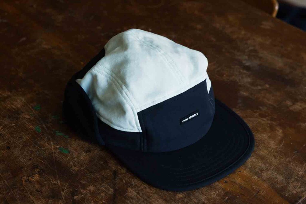 Black and white athletic cap with logo patch.