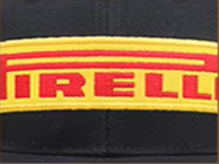 Yellow and red Pirelli logo on black fabric background.