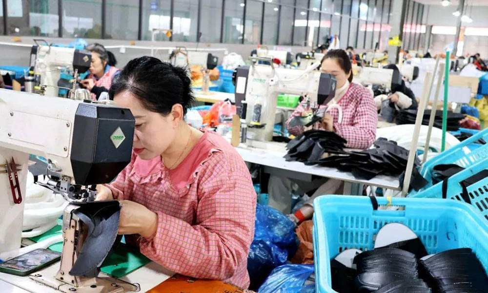 Workers sewing caps in a factory production line