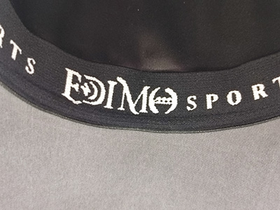 Close-up of black hat inner band with white printed logo text.