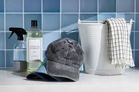 Black cap placed near cleaning supplies on blue tiled surface