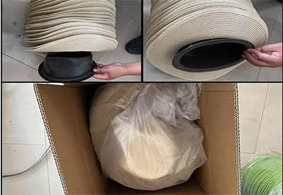 Hands placing straw hats into box for packaging.