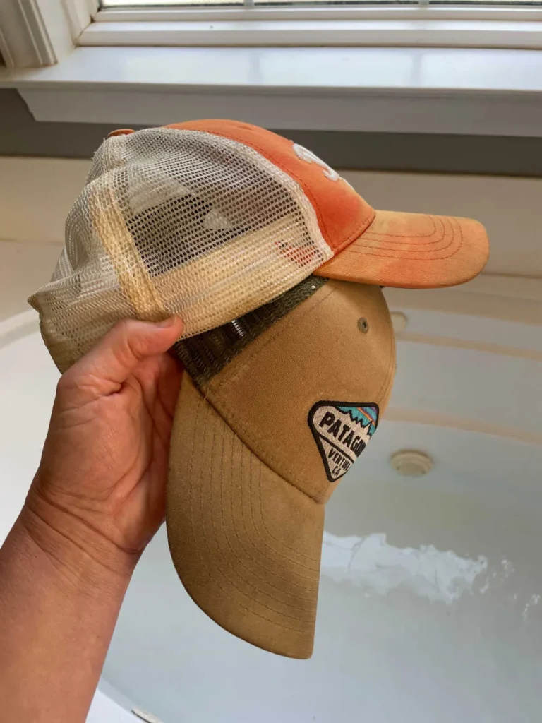 Hand holding two mesh-back baseball caps