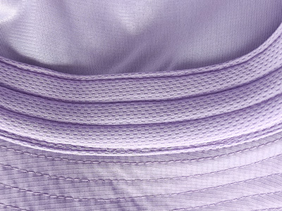 Close-up of purple fabric stitching and textured hat brim.