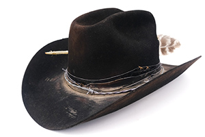 Black cowboy hat with feathers and visible wear marks.