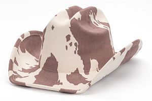 White and brown cow-patterned cowboy hat with wide brim.