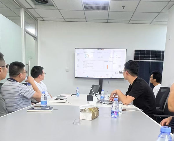 Group of people watching presentation on large screen in meeting room.