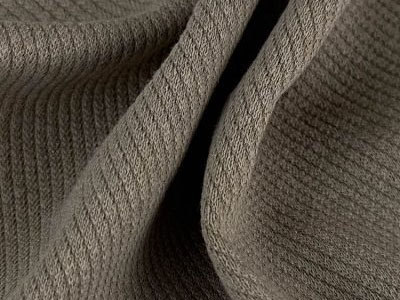 Close-up of textured brown knit fabric with folds.