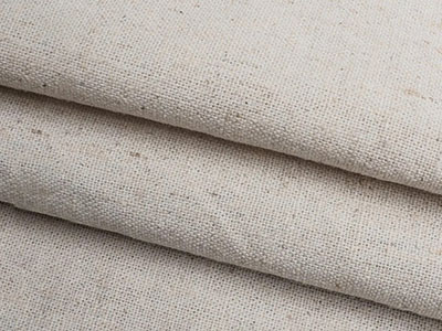 Close-up of folded beige linen fabric with natural texture and fibers.
