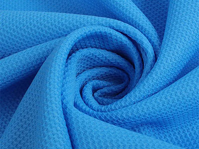 Close-up of blue breathable mesh fabric twisted into swirl shape.