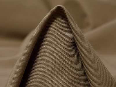 Close-up of folded brown fabric with fine ribbed texture.