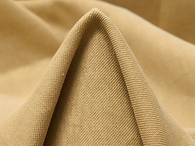 Close-up of light brown fabric folded to form a peak with textured weave.