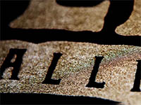 Close-up of textured fabric with printed black letters on brown background.