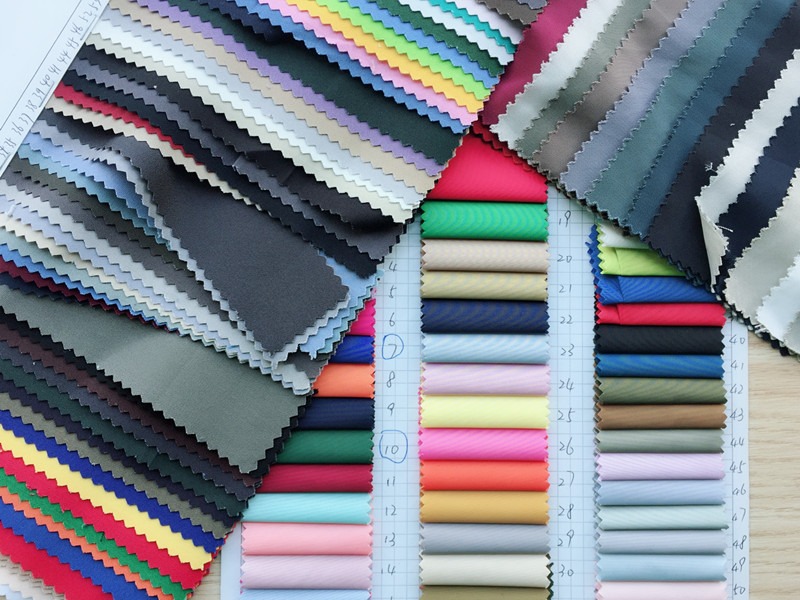 Various colorful fabric swatches organized on a table with labels.