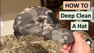 Hand holding camo cap for deep cleaning