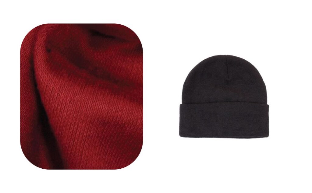Close-up of red acrylic fabric and a black knitted beanie hat.