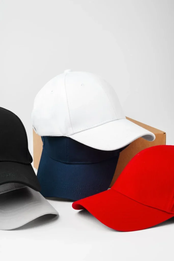 Black, white, navy, and red baseball caps stacked together.