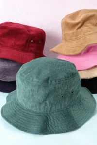 Multiple corduroy bucket hats in various colors stacked together.