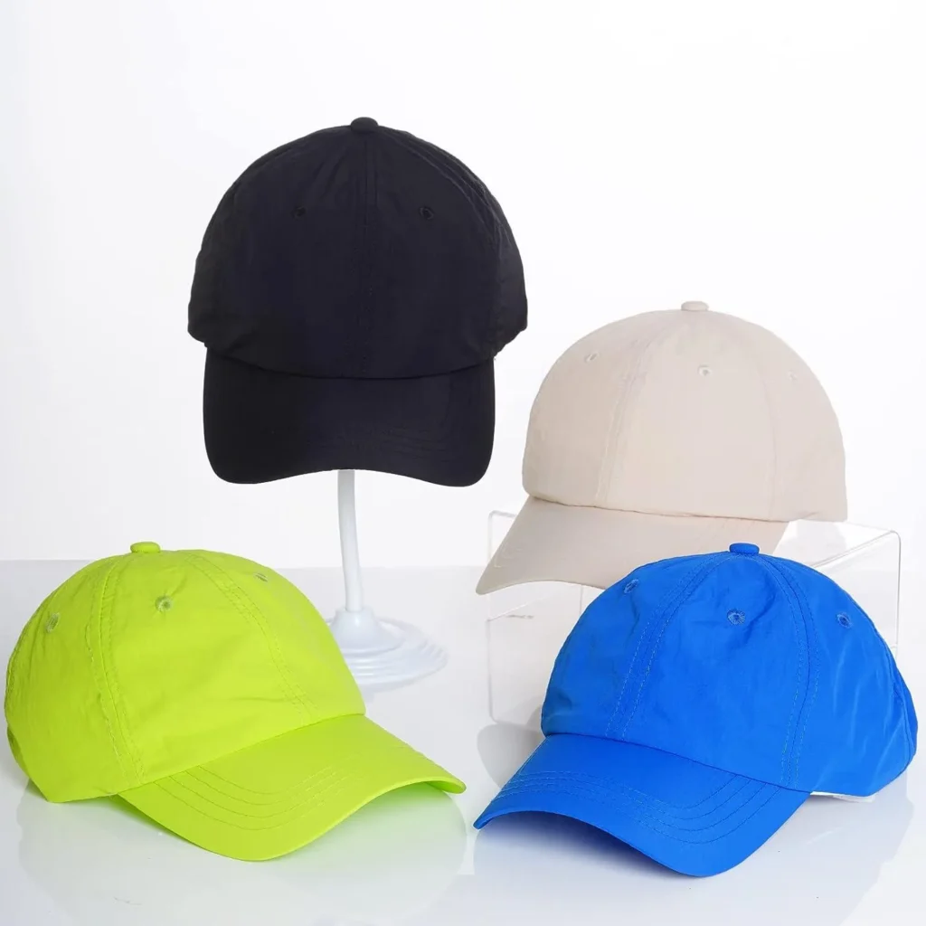 Four baseball caps in black, beige, neon green, and blue on display stands