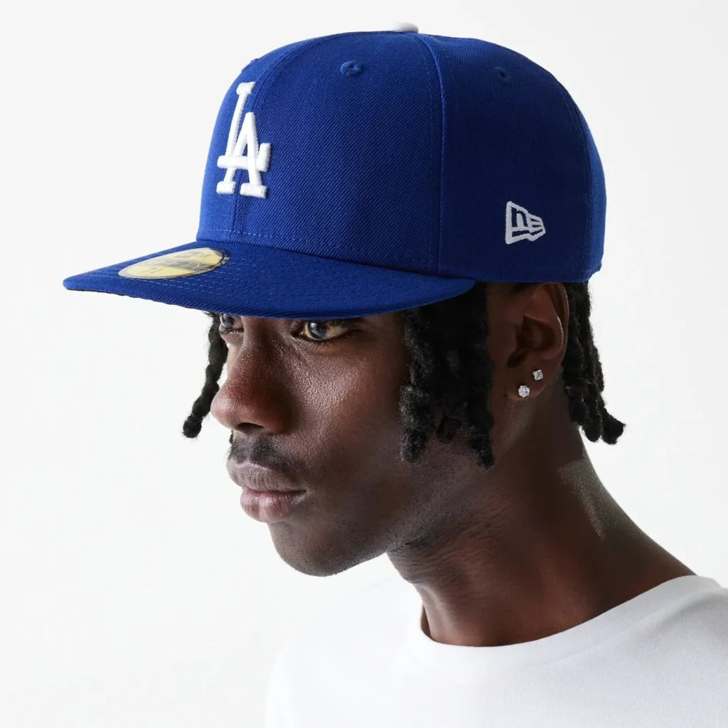 Man wearing blue Los Angeles Dodgers cap looking sideways.
