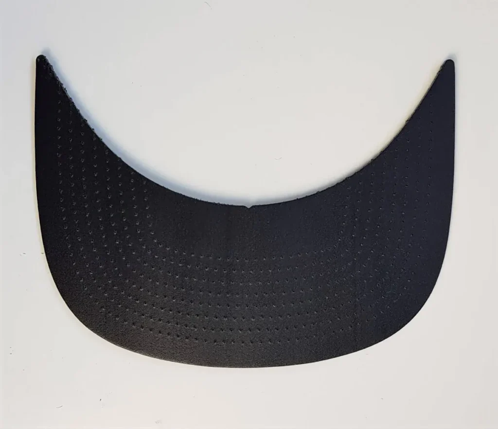A black curved bill insert with perforations, used for shaping the brim of caps.