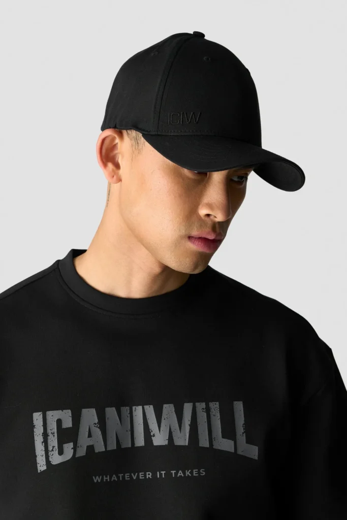 Man wearing black cap and black ICANIWILL sweatshirt