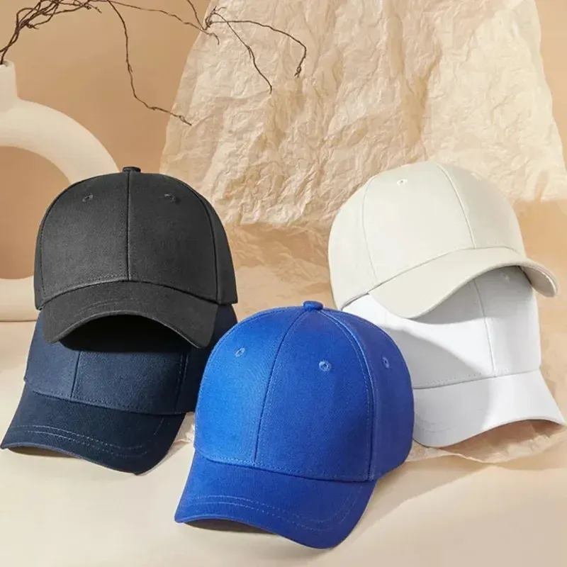 Black, navy, blue, and white baseball caps displayed on beige background.