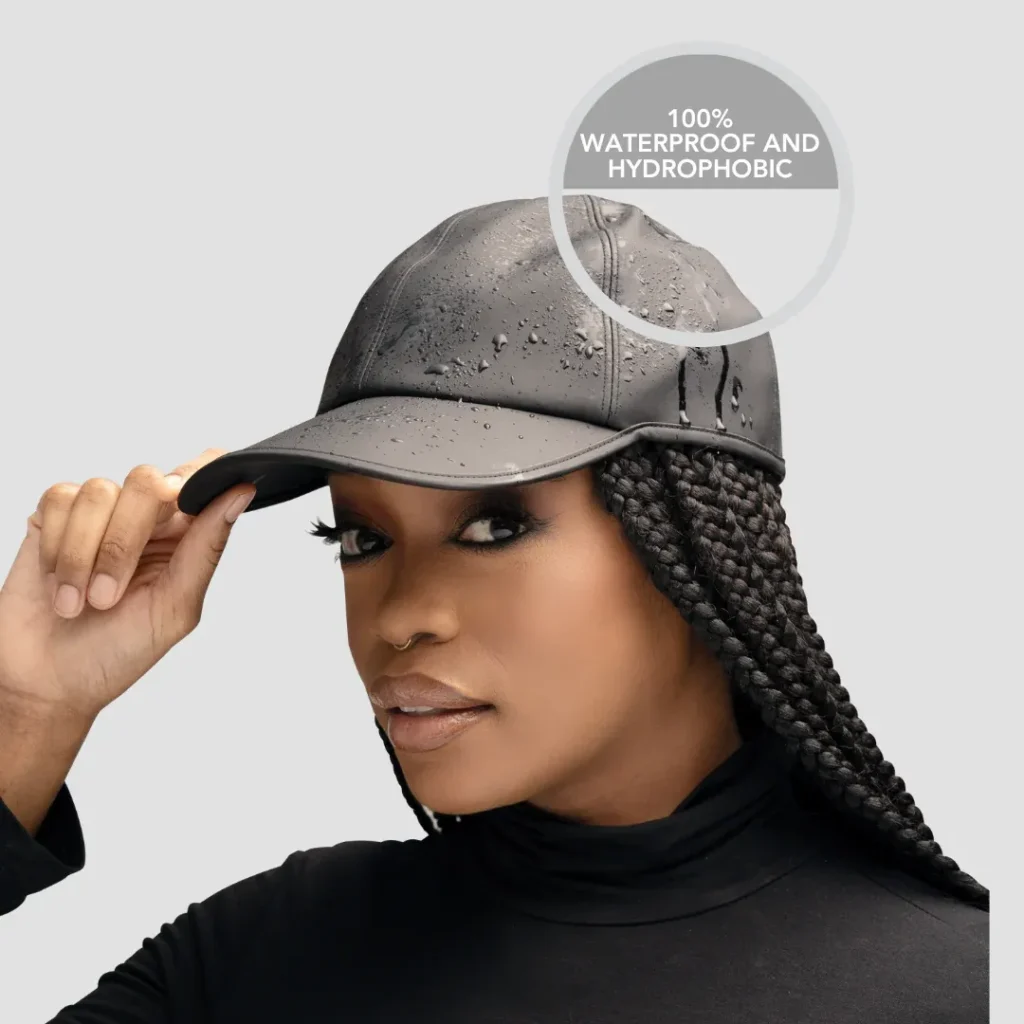 Woman wearing black waterproof baseball cap with water droplets on it