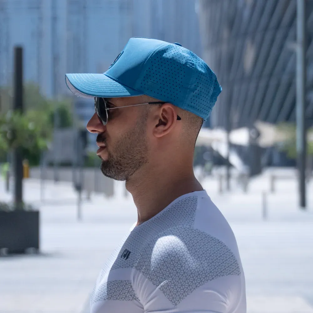 Man wearing a blue sport cap with sunglasses outdoors