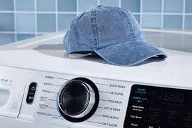 Blue denim cap placed on top of washing machine in laundry room.