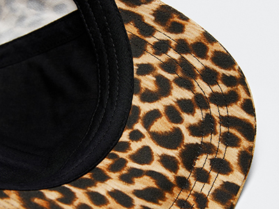 Close-up of hat brim with leopard print pattern and black inner lining.