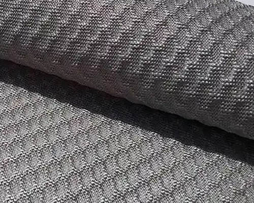 Close-up of grey fabric with hexagonal textured pattern.