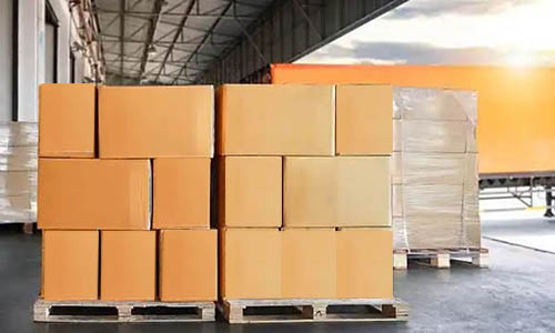 Stacks of cardboard boxes on pallets in warehouse loading dock.