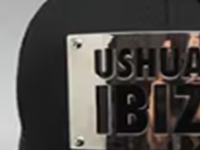 Close-up of black cap with metal Ushuaia Ibiza logo plate.