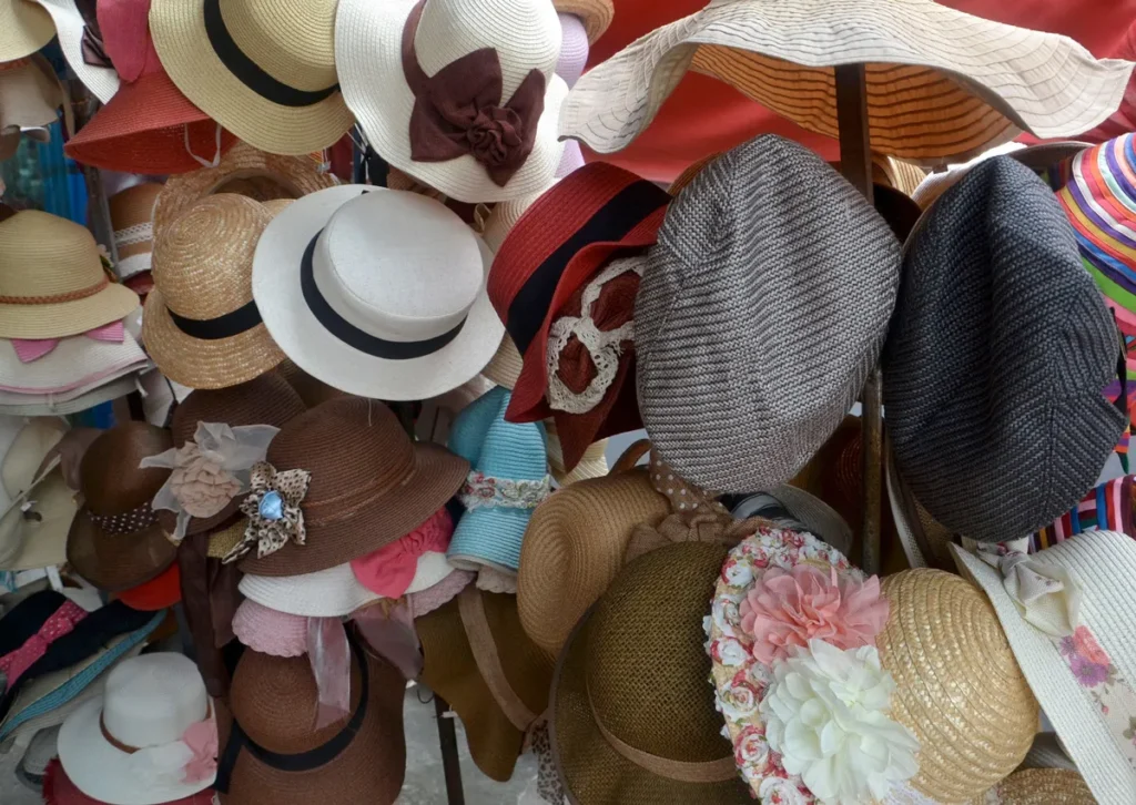 Assorted hats displayed on racks in a colorful shop setting