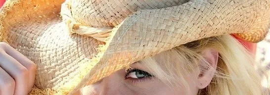 Woman wearing a wide-brimmed woven straw hat outdoors