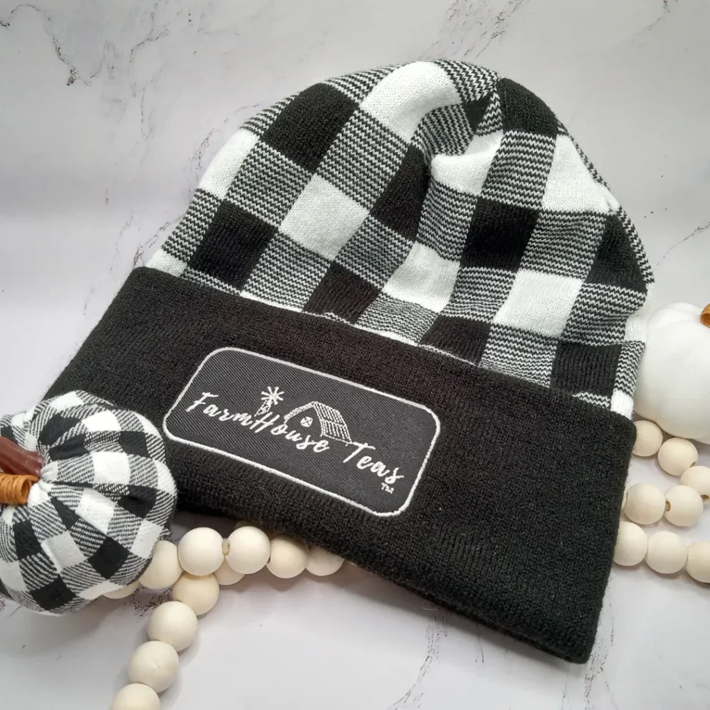 Black and white plaid beanie with "Farmhouse Texas" patch on cuff.