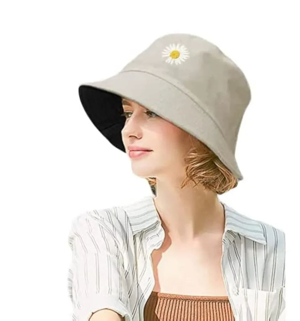 Woman wearing a beige bucket hat with a small daisy embroidery.